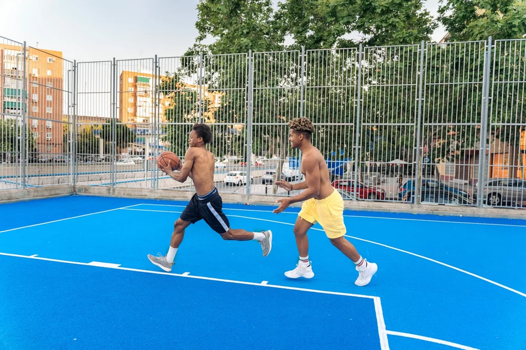 sporty friends playing basketball
