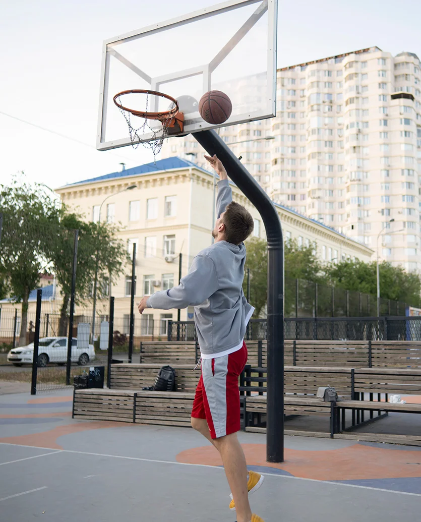 a man in a grey hoodie and red shorts prepares