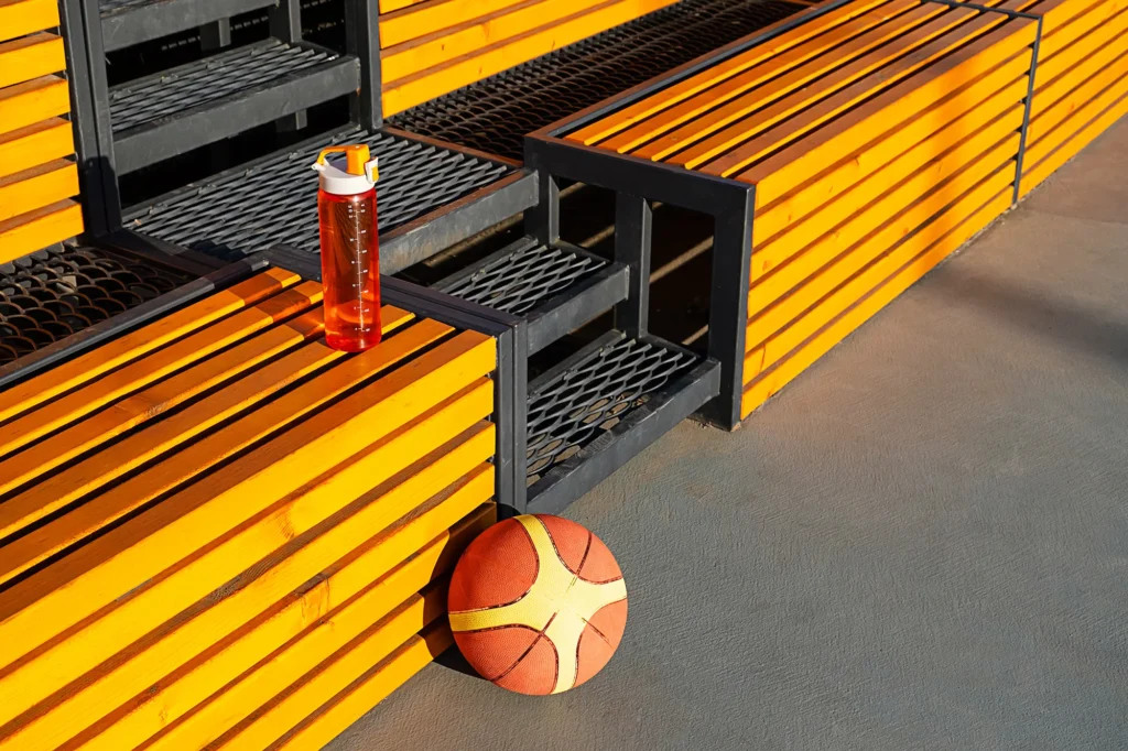 basketball and water bottle on wooden bench