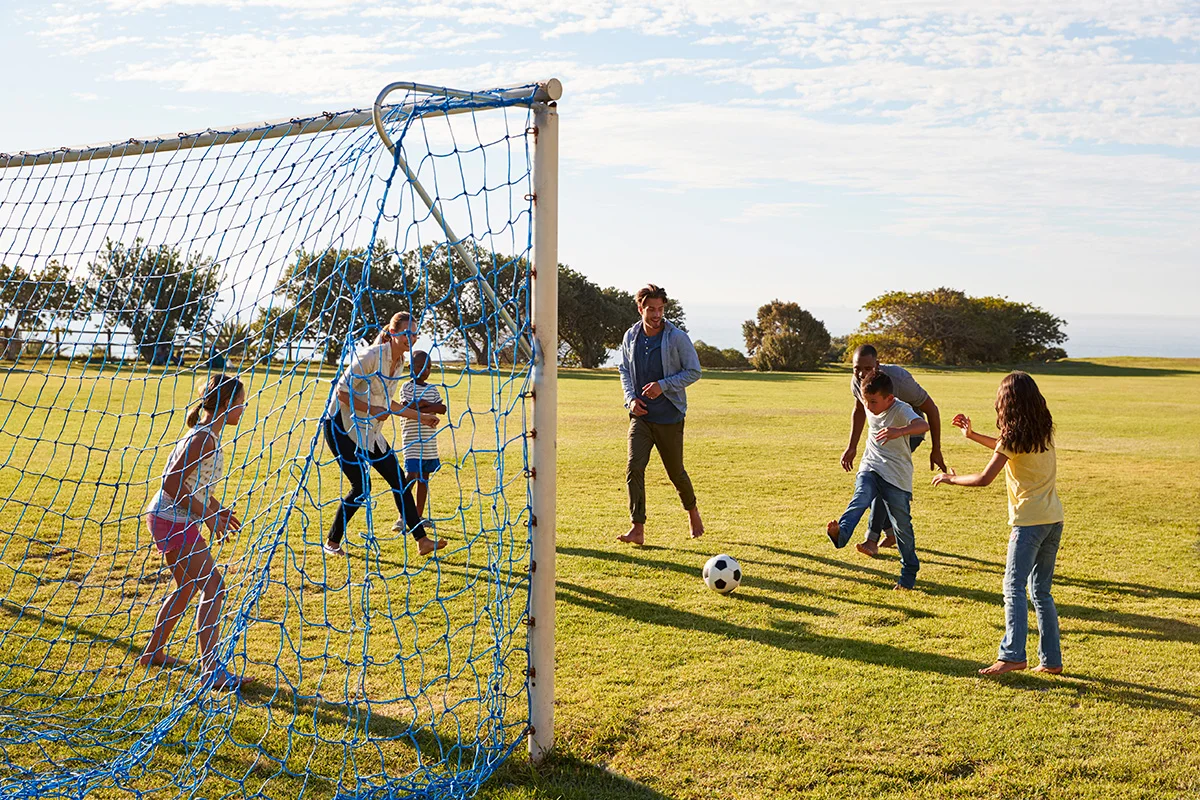 girl defending goal during family football game