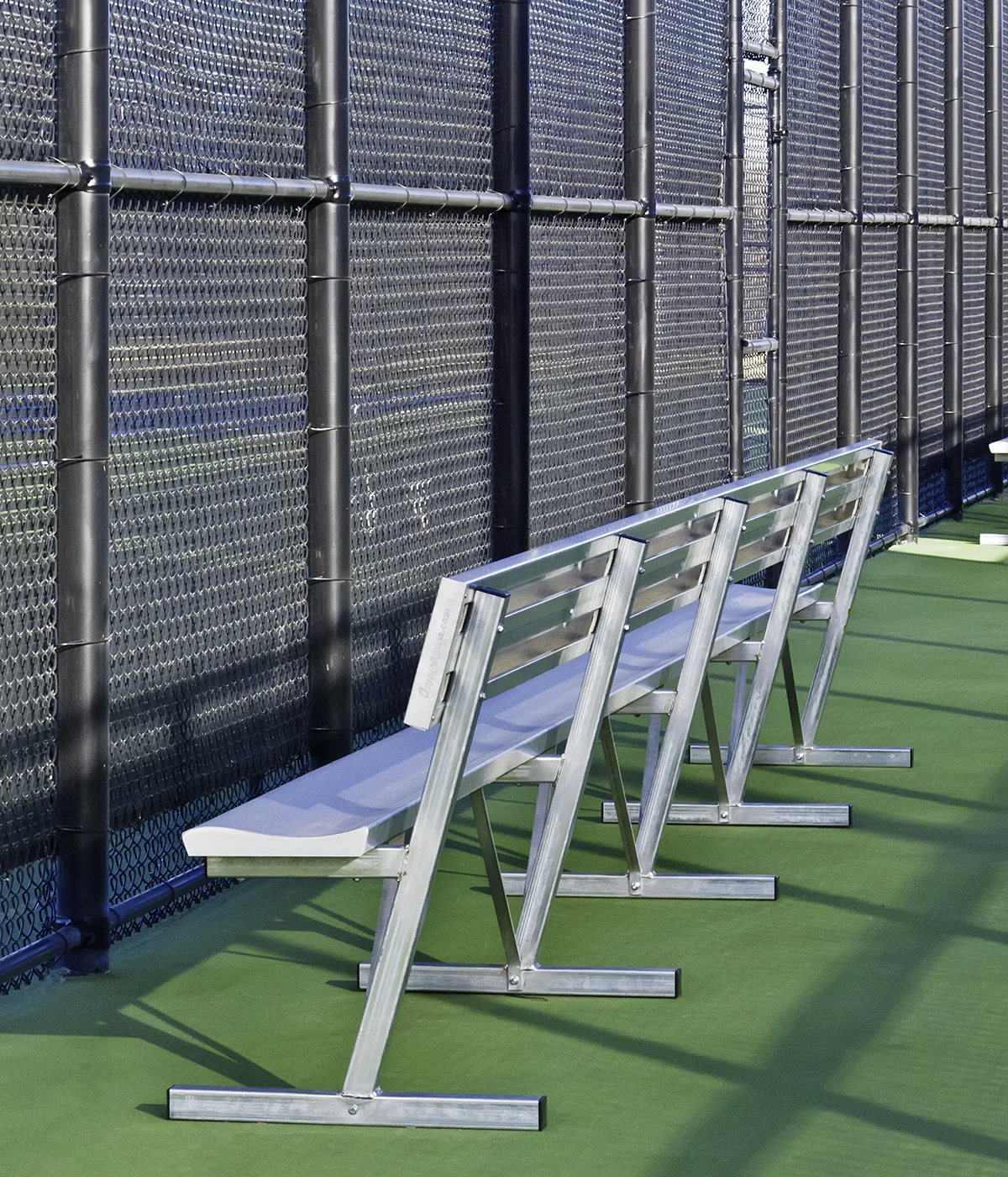shiny aluminum bench behind fence